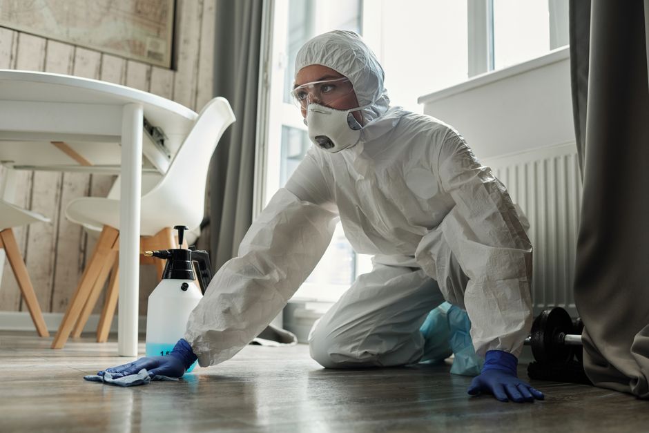 Technician in protective hazmat gear performing sewage cleanup